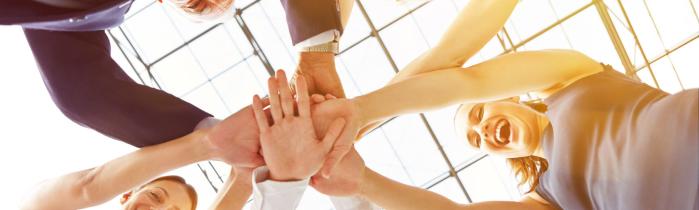 A circle of people with their hands together
