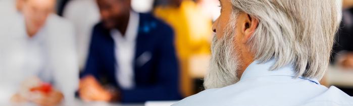A man lecturing people blurred in the background